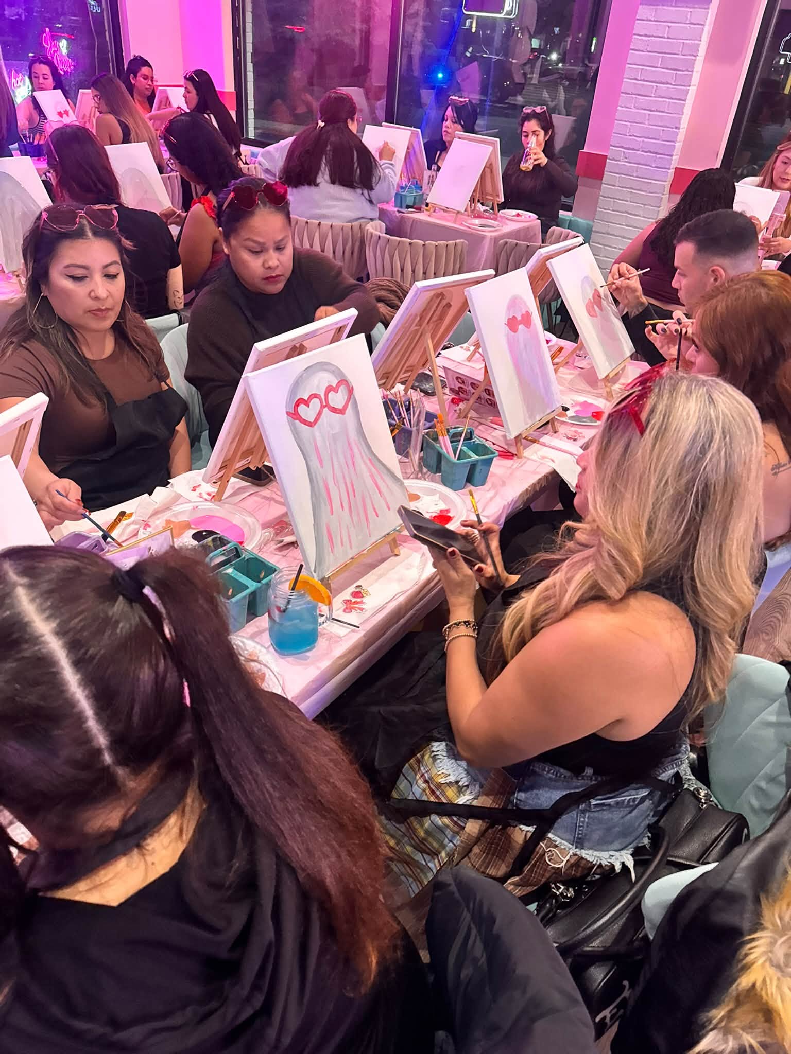 Guests painting canvases at a Sip & Paint event